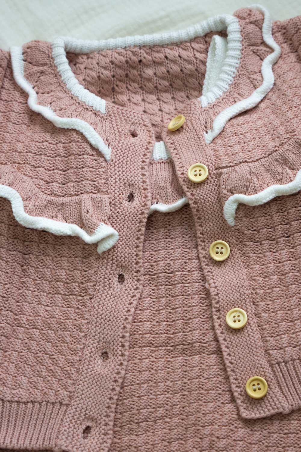 conjunto de cardigan con volante y peto de punto color rosa