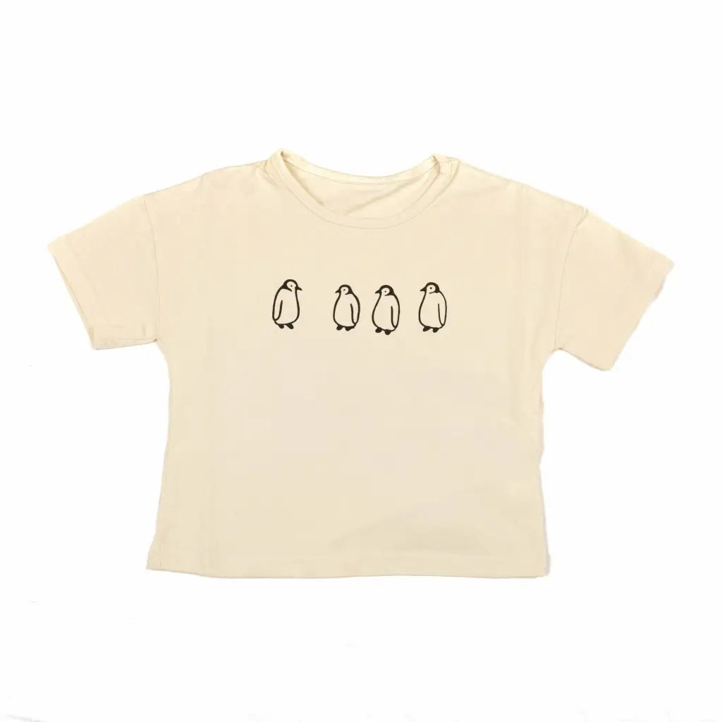 camiseta color beige con pinguinos