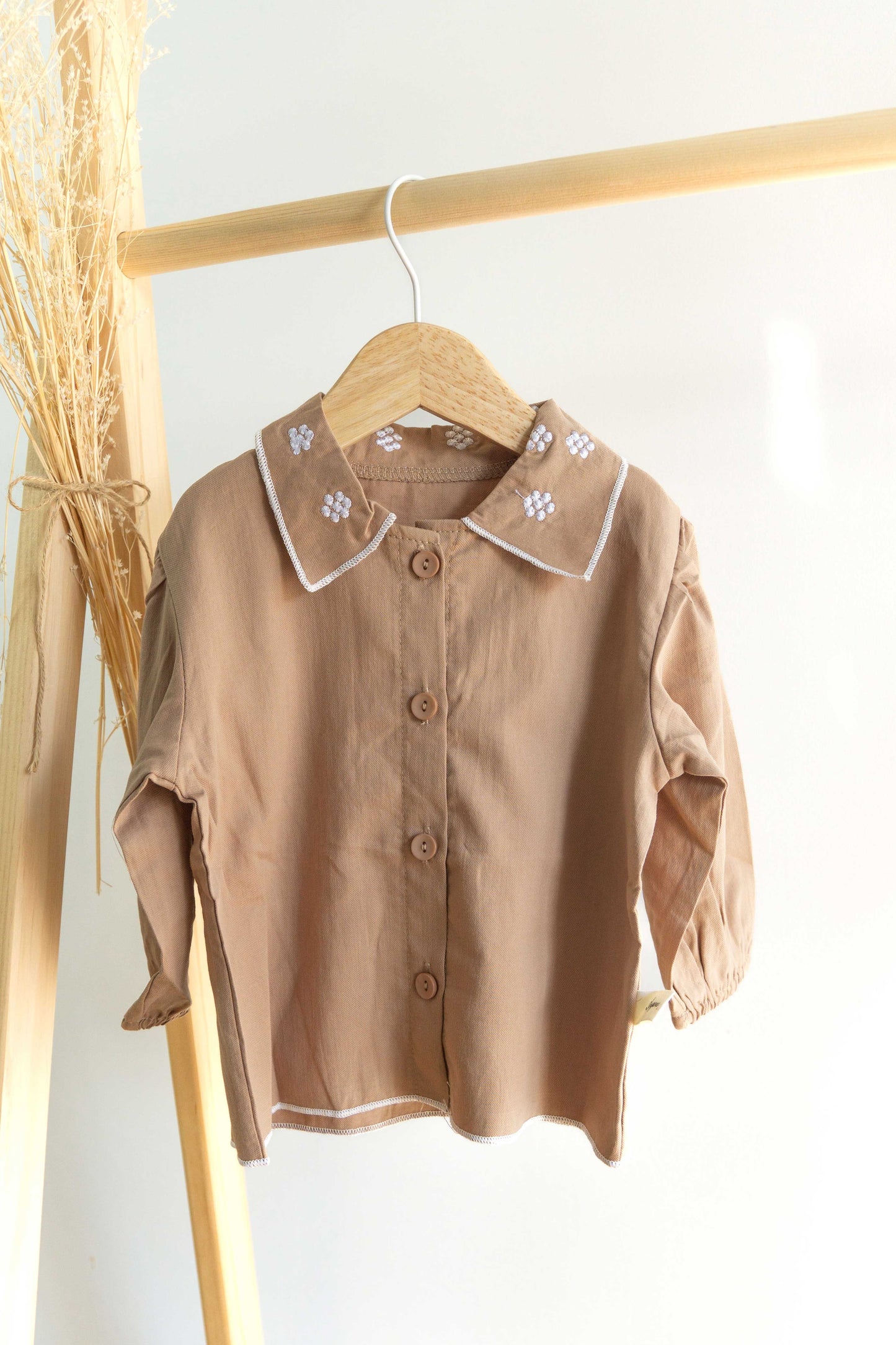 camisa color marron con detallas de flores blancas en cuello 